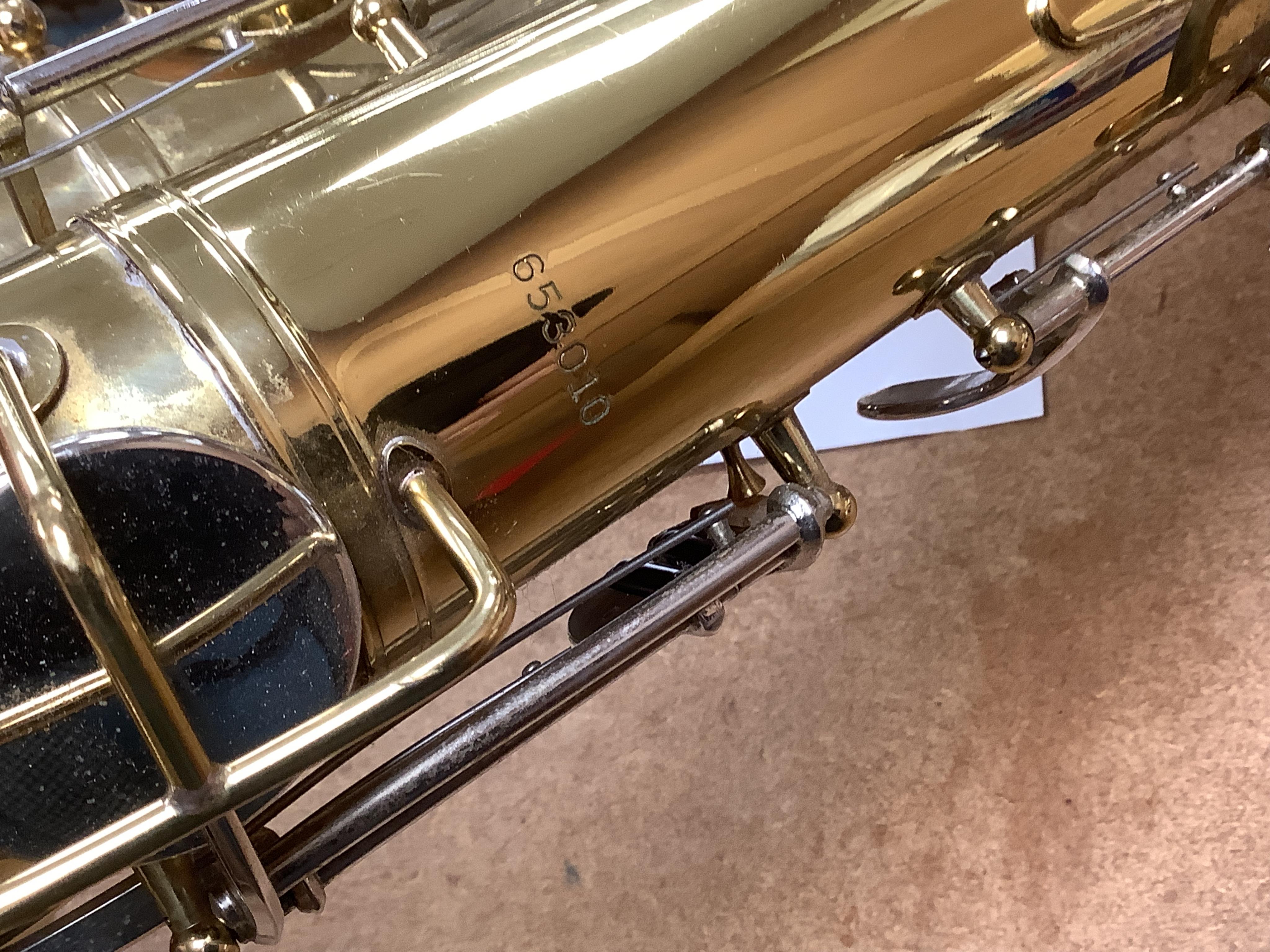 A cased Buescher Aristocrat tenor saxophone and stand